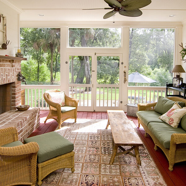 screen porch with fireplace and wicker furniture